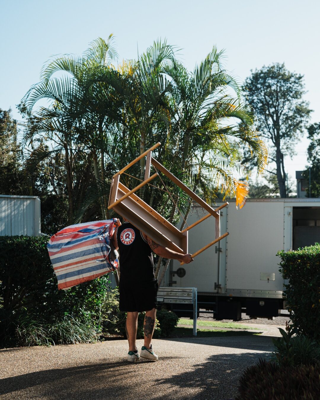 Relocation Rangers mover carrying a chair and belongings to the moving truck in Brisbane